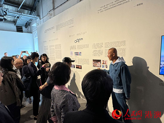 圖為蔡國強(qiáng)為觀眾導(dǎo)覽其合作者AI的作品。人民網(wǎng)記者 富子梅攝